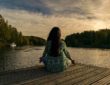 asana, joga nad jeziorem - kobieta siedząca po turecku